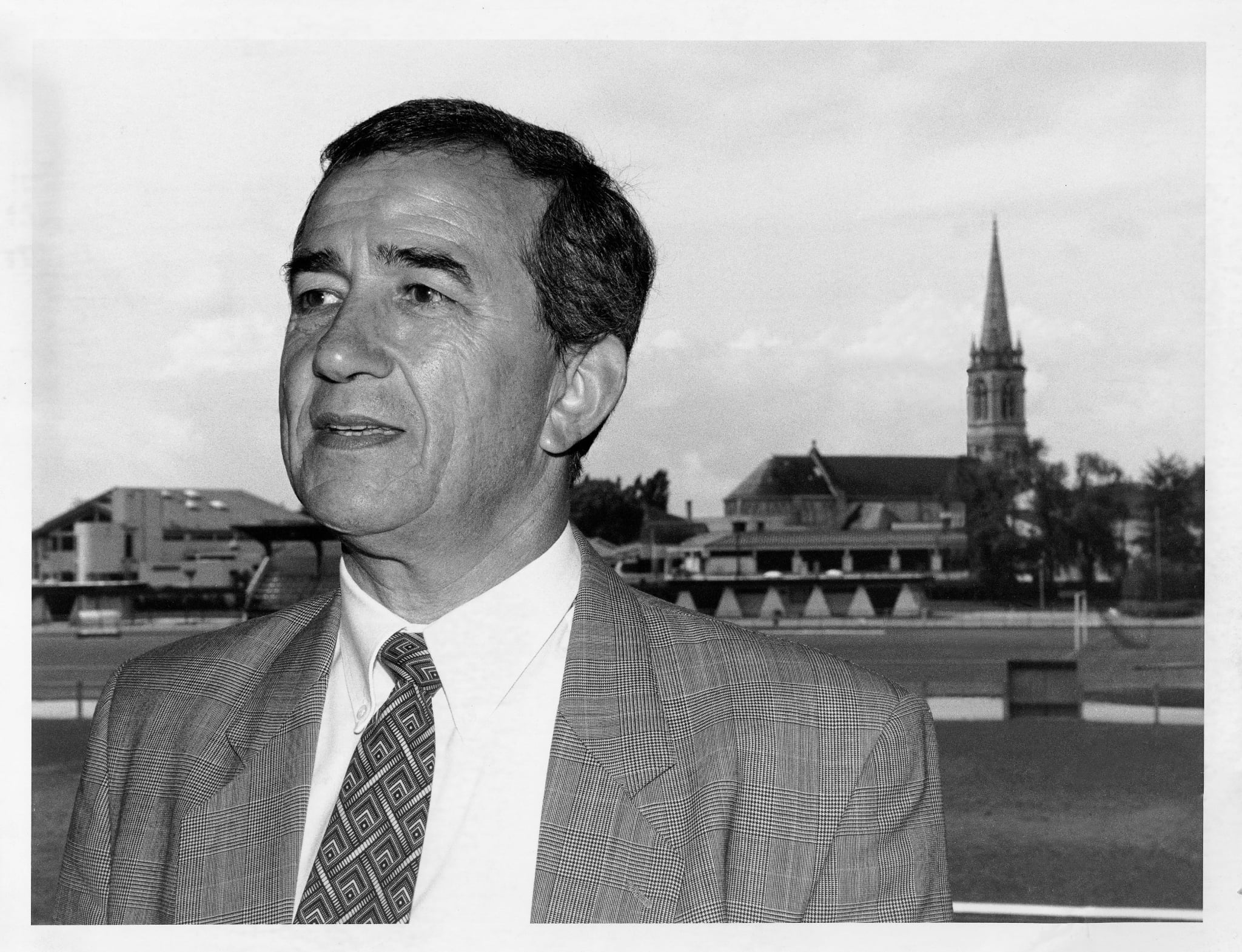Portrait of Henri ARNOUD standing at Stade Abel Laporte with the church of Le Haillan in the background.
